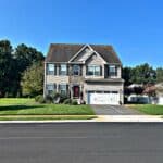 Before and after views of a cleared property in Sussex County, thanks to professional tree removal services.